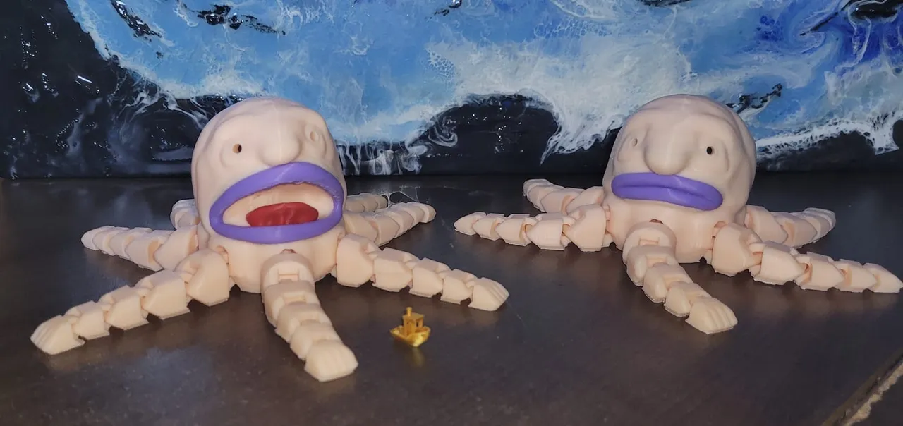 Two 3D-printed articulated octopuses on a desk