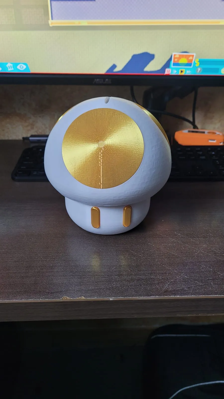 A 3D-printed Super Mario mushroom coin bank, white with a metallic-gold cap